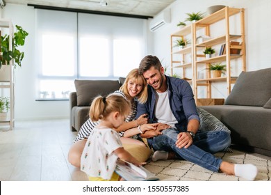 Parents playing with daughter during family time at home - Powered by Shutterstock