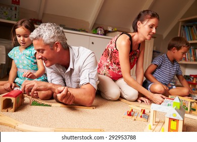 Parents Playing With Kids And Toys In An Attic Playroom