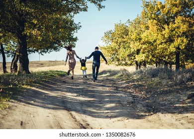 Parents playing with their child in the field. Happy family life style concept. - Shutterstock ID 1350082676