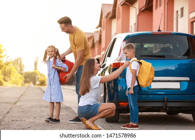 Parents Saying Goodbye To Their Children Near School