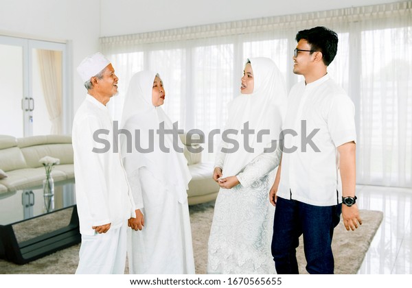 Parents with son and daughter\
gathering together for Eid Mubarak celebration at\
home