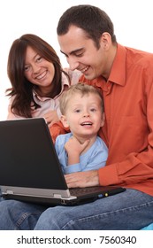 parents and son having fun with computer game on the sofa