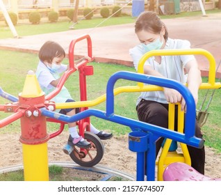 Parents Take Students In School Uniforms For Family Activities. Play On The Playground Equipment Rides With Bikes, Circles, And Fun For Two Evening After School