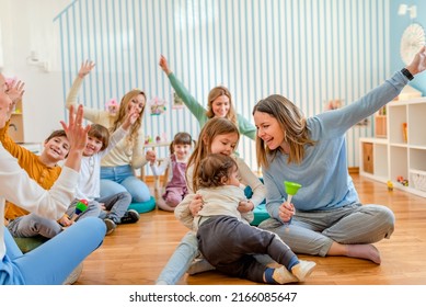 Parents taking part in the music class of a kindergarten. Teacher and parents working together. Preschool partnership with parents.
 - Shutterstock ID 2166085647