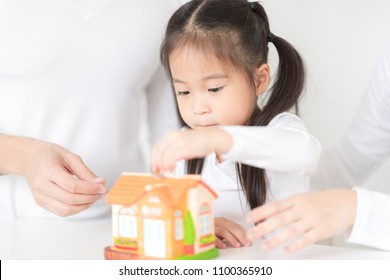 Parents Are Teaching Daughter On Saving Money And Financial Planning.