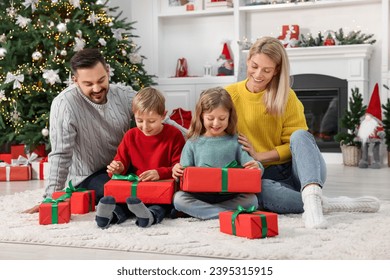 Parents and their children opening Christmas gifts at home - Powered by Shutterstock