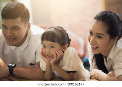 Parents And Their Children Are Watching On Television. Sofa Home