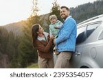 Parents and their daughter near car in mountains. Family traveling