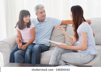 Parents with their daughter sitting on sofa at home