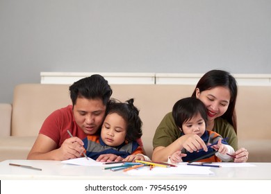Parents and theis children drawing together at home