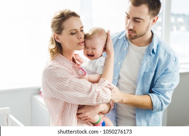 Parents trying to calm down crying infant daughter