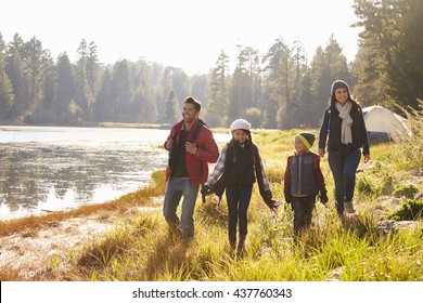 Parents and two children walking near a lake, close up