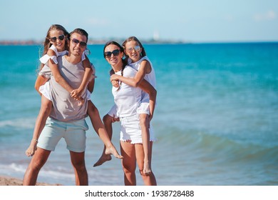 Parents with two kids have fun on the beach