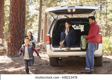 Parents Watch Kids And Prepare For Hike At The Back Of Car