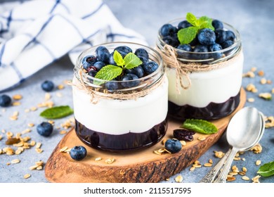 Parfait With Blueberry, Granola And Jam In Two Glass Jars.