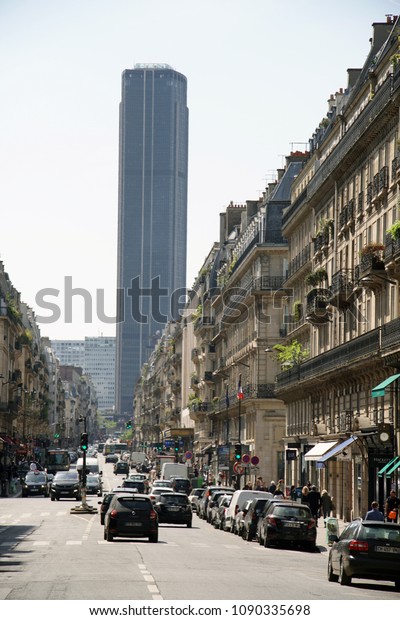 PARIS - APRIL 21: Cars driving along Rue de Rennes\
with Tour Montparnasse in the background in Paris, France on April\
21st, 2018.