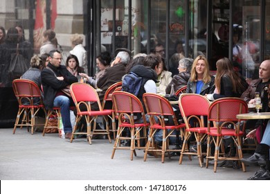 PARIS - APRIL 27 : Parisians And Tourist Enjoy Eat And Drinks In Cafe Sidewalk In Paris, France On April 27, 2013. Paris Is One Of The Most Populated Metropolitan Areas In Europe