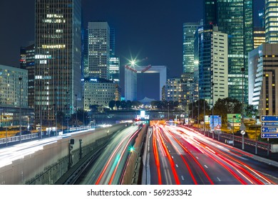 Paris Cityscape With Modern Buildings In Business District La Defense With Dynamic Street Traffic And Car Lights By Night. Glass Facade Skyscrapers. Concept Of Economics, Finances. Copy Space. Toned