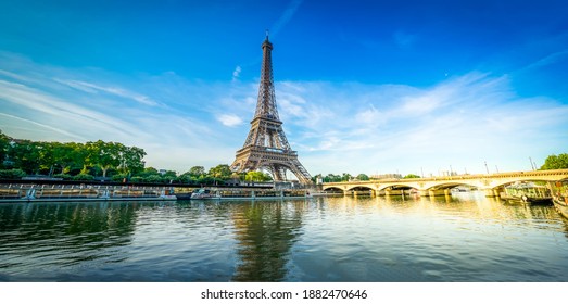 Paris Eiffel Tower Reflecting In River Seine With Bridge Pont DIena In Paris, France. Eiffel Tower With Sunshine