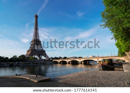 Paris Eiffel Tower reflecting in river Seine with bridge Pont dIena in Paris, France. Eiffel Tower is one of the most iconic landmarks of Paris.