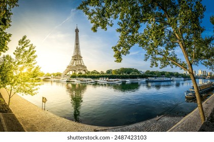 Paris Eiffel Tower and river Seine with sunrise sun in Paris, France. Eiffel Tower is one of the most iconic landmarks of Paris, panorama with sunshine