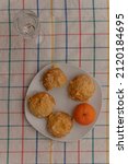 Paris, France - 01 28 2022: A glass of champagne, gougeres and mandarin on a table at home