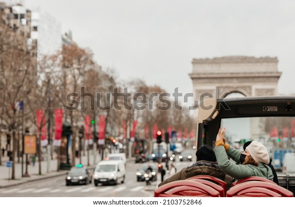 Paris. France. 01.11.2022 Tourists taking\
photos of the Paris tourist bus. Detrans the triumphal arch. Avenue\
des Champs-Élysées