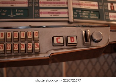 Paris, France - 10 30 2022 : Close Up Sur L'emplacement D'insertion Des Piéces D'un Jukebox Wurlitzer 1100. A Few Songs Of The Tracklist Songs Are Visible In The Upper Part Of The Image, Blurred