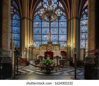 Paris, France 10-07-18. Image of Notre Dame Paris Side altar in ambulatory with stained glass windows, columns, statue of Mary