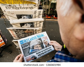 Paris, France - 29 Mar 2019: Newspaper stand kiosk selling press with senior male hand buying latest Het Laatste Nieuws dutch press featuring Theresa May Prime Minister Brexit news on front cover  