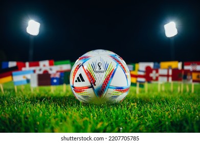 PARIS, FRANCE, 6 SEPTEMBER, 2022: Official Adidas World Cup Football Ball Al Rihla On Green Grass. Flags Of All 32 Nations Participate On FIFA World Cup In Qatar 2022. Soccer Ball At Stadium In Night