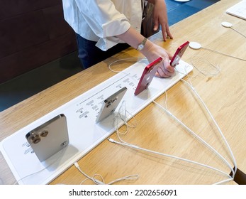 Paris, France - 9 Sep 2022: Side View Of Woman Hands Comparing The Latest Apple Computers Iphone 14 Pro Next To 13 Mini Smartphones Inside Apple Store