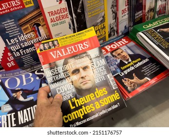 Paris, France - Apr 11, 2022: POV Male Hand Buy Valeurs Magazine Newspaper Press Headlines With French President Emmanuel Macron On The Coiver - Presidential Election Of 2022