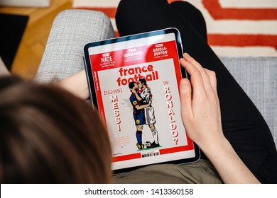 Paris, France - Apr 15, 2019: Woman reading on iPad Pro Apple News Plus France Football digital newspaper featuring breaking news on cover Who are you, Messi or Ronaldo
