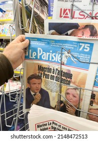 Paris, France - Apr 21, 2022: POV Male Hand Buy Le Parisien Newspaper Press Headlines After Debate Between Marine Le Pen And French President Emmanuel Macron - Presidential Election Of 2022