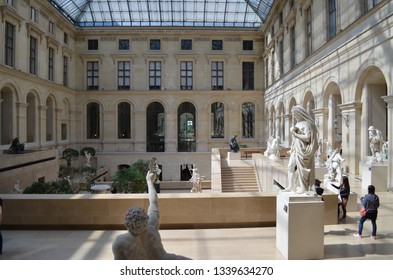 PARIS / FRANCE - APRIL 20 2013: A few tourists visit the Louvre Museum and rest in an internal gallery