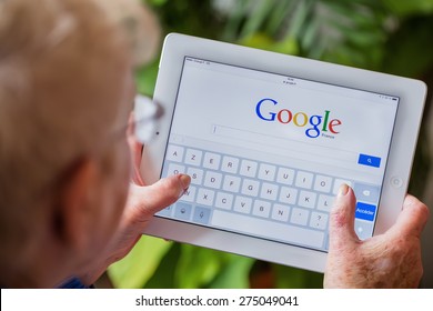 Paris, France - April 27, 2015: Senior Woman Using Tablet With Google Search Home Page On A Ipad Screen