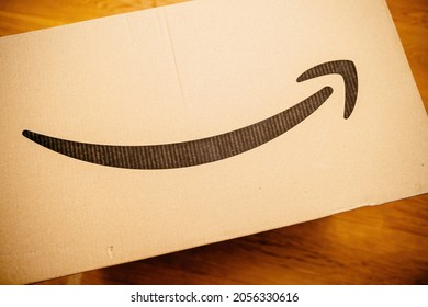 Paris, France - Aug 20, 2021: Amazon Prime Cardboard Box Parcel On The Wooden Floor - Smiling Amazon Logotype Of The World Biggest Company Founded By Jeff Bezos