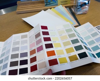 Paris, France - Aug 23, 2022: POV Male Hand Holding Swatch Of Colors From Farrow And Ball Luxury British Paint