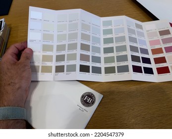 Paris, France - Aug 23, 2022: Personal Perspective Male Hand Holding Swatch Of Colors From Farrow And Ball Luxury British Paint