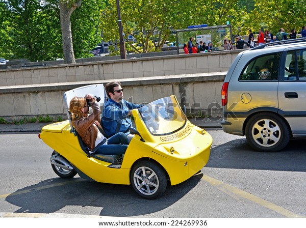 PARIS, France - August\
22, 2014: Tourists on a rented car photograph attractions. Cars\
with navigation system and audio guide, have already attracted many\
tourists