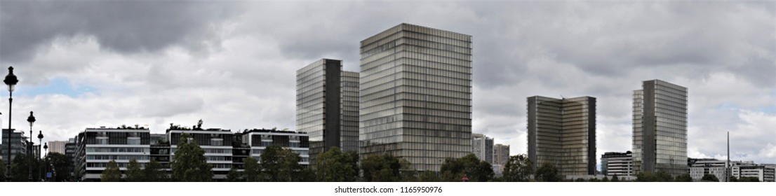 Paris, France, Date 8.13.2018, Time 12 O'clock And 6 Minutes, Panoramic View   To The Four Buildings Of The Bibliothèque Nationale De France (site François-Mitterrand), In Foreground Shore River Seine