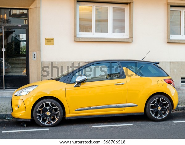PARIS, FRANCE - DEC 1, 2016: Beautiful yellow\
Citroen sport two-doors French car parked in front of a house -\
tilt-shift lens