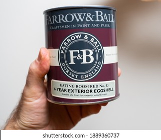 Paris, France - Dec 13, 2020: POV Male Hand Holding Isolated On White Background Package Of Farrow And Ball Dorset England Eating Room No 43 6 Years Exterior Eggshell Paint For Metal And Wood