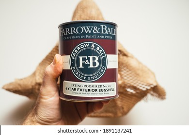 Paris, France - Dec 13, 2020: POV Male Hand Holding Isolated On White And Corrugated Paper Background Package Of Farrow And Ball Dorset England Eating Room No 43 6 Years Exterior Eggshell Paint For