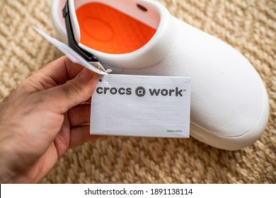 Paris, France - Dec 13, 2020: POV Male Hand Holding Paper Advertising Tag Of Crocs At Work Comfortable Shoes With Price Tag Etiquette