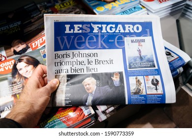 Paris, France - Dec 14, 2019: Man Holding Near Press Kiosk The Day After UK Prime Minister Boris Johnson's Conservative Party Won A Landslide Early General Parliamentary Victory