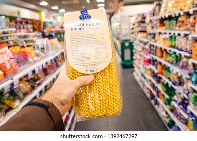 Paris, France - Dec 27, 2017: Man Hand POV Personal Perspective Holding Fusili Lunghi Bucati Din Napoli Pasta In Modern Supermarket With Multiple Product On The Shelves