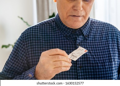 Paris, France - Dec 28, 2019: Senior Man Reading The Price Tag And Garment Composition Of The New Flannel Checked Long Sleeved Shirt During Measures