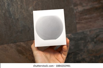 Paris, France- Dec 9, 2020: POV Personal Perspective Male Hand Holding New Apple Computers HomePod Personal Assistant Sound Device With Siri - Stone Wall Background